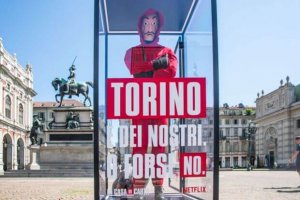 La casa di carta: Manichino in tuta rossa con maschera di Dalì e scritta: "Torino è dei nostri?"